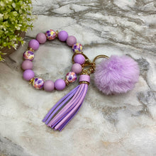 Load image into Gallery viewer, Silicone Bracelet Keychain - Tassel &amp; Pom Pom- Purple &amp; Floral
