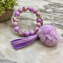 Load image into Gallery viewer, Silicone Bracelet Keychain - Tassel &amp; Pom Pom- Purple &amp; Floral
